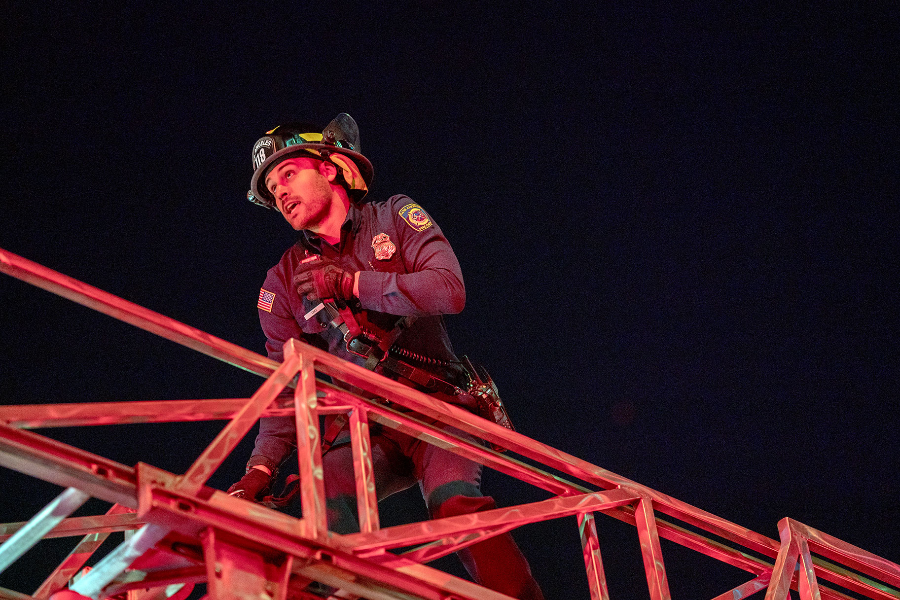 Firefighter climbing the fire truck ladder to get inside an apartment