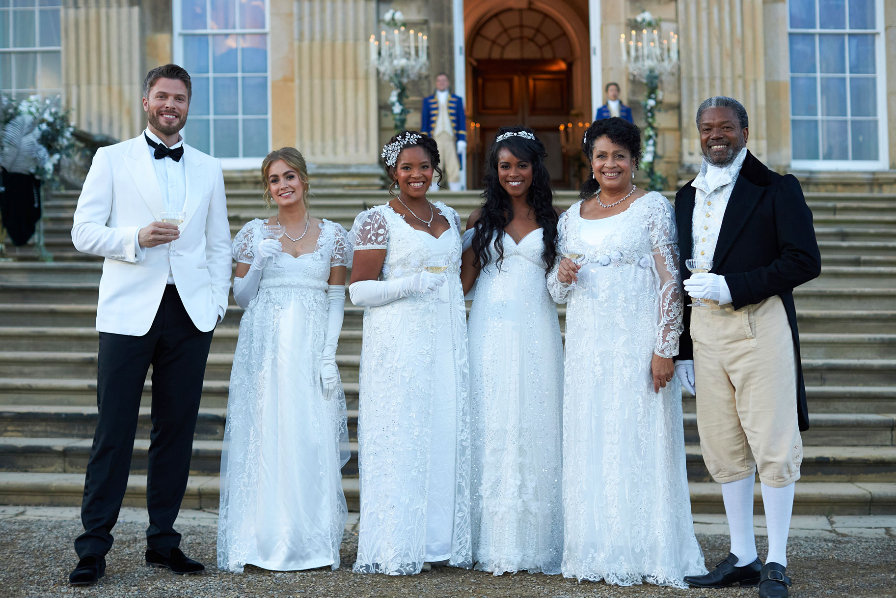 Nicoel Remy with her parents, sister, and friends, all dressed in white standing outside of the castle