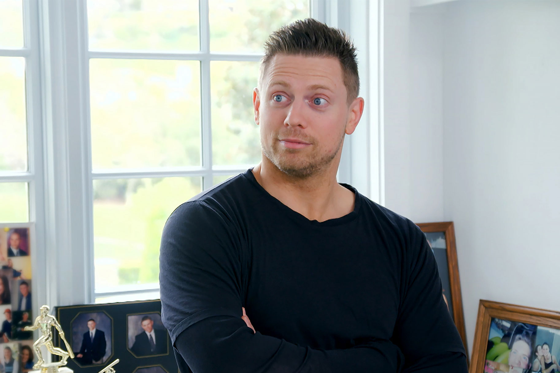 The Miz wearing a long sleeve black shirt with a surprised look on his face