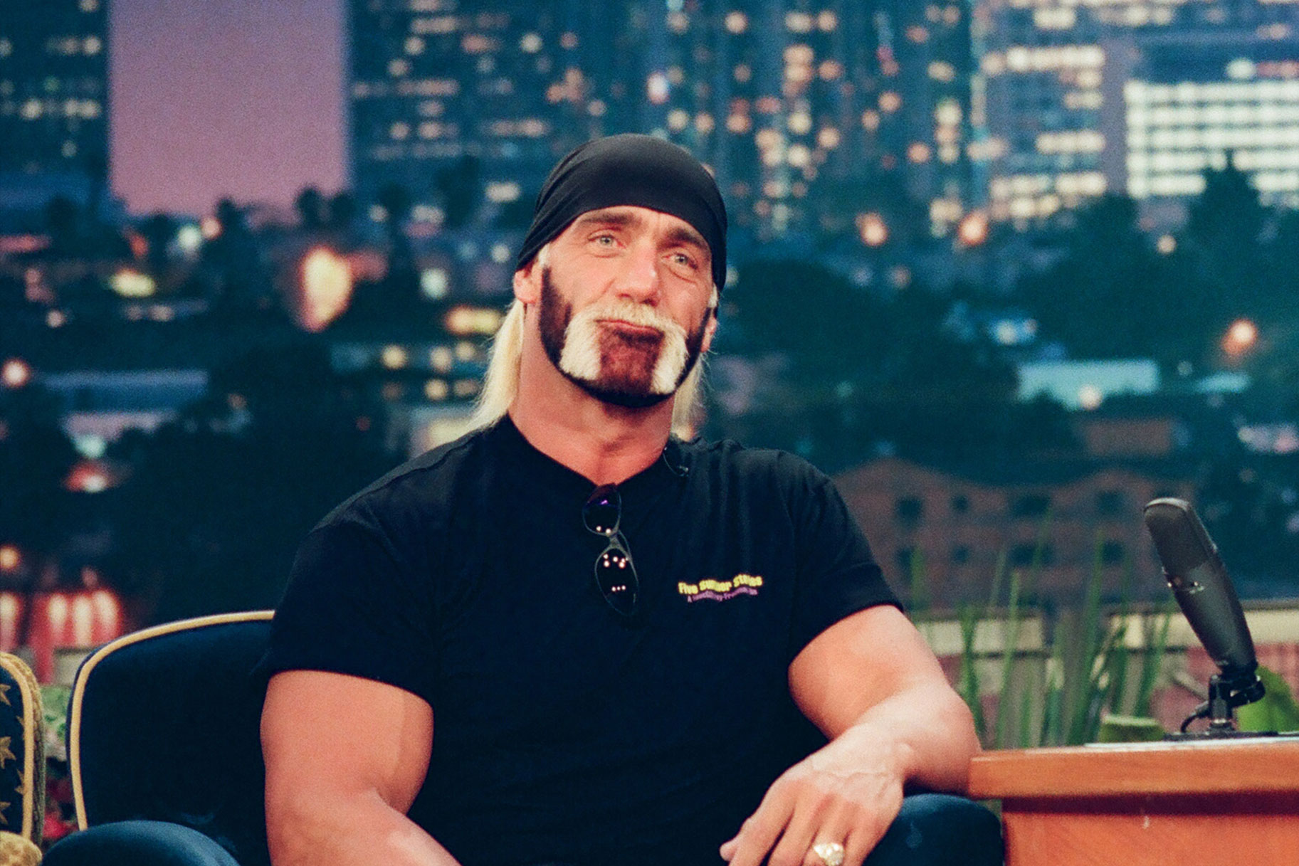 Hulk Hogan sitting in a chair wearing a black shirt