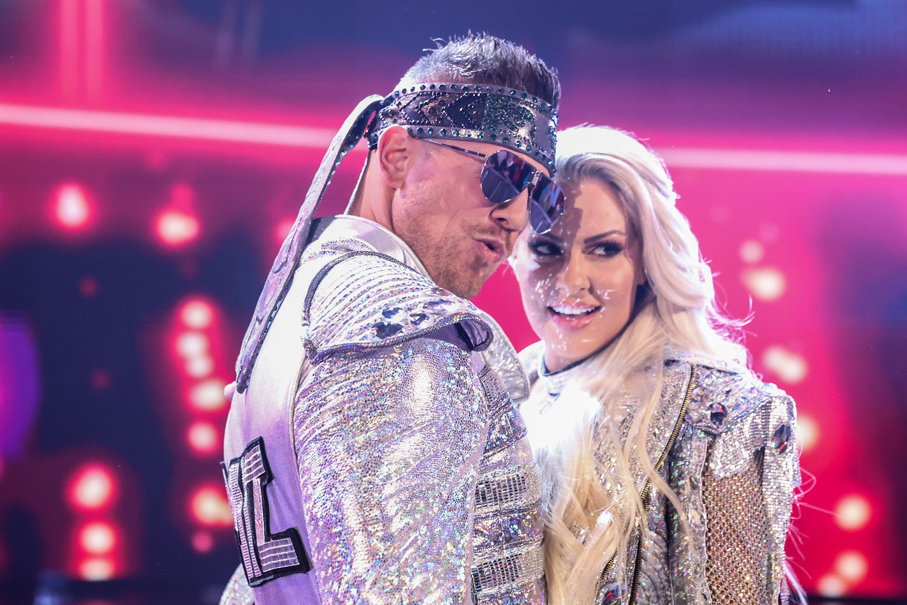 The Miz and Maryse posing together while wearing sparkly silver costumes
