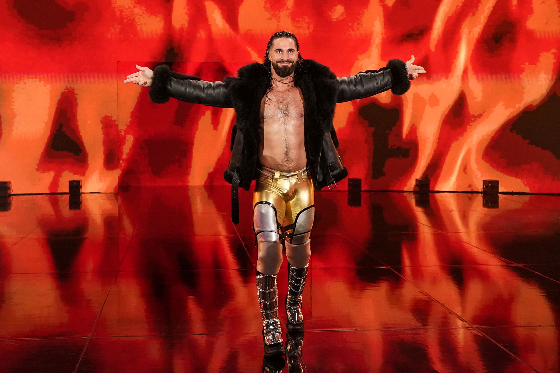 Seth Rollins walking to the ring with both arms outstretched