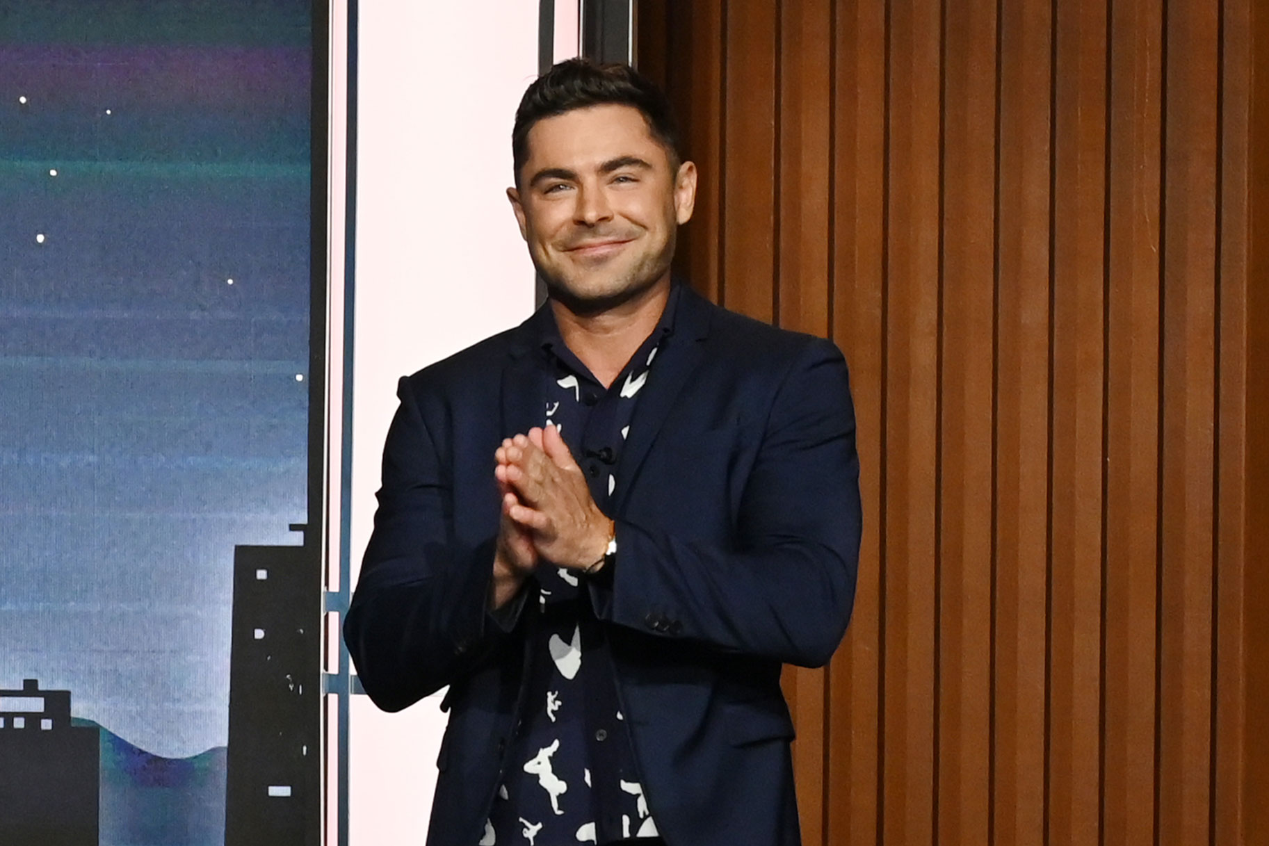 Zac Efron smiling on the set of a late night show