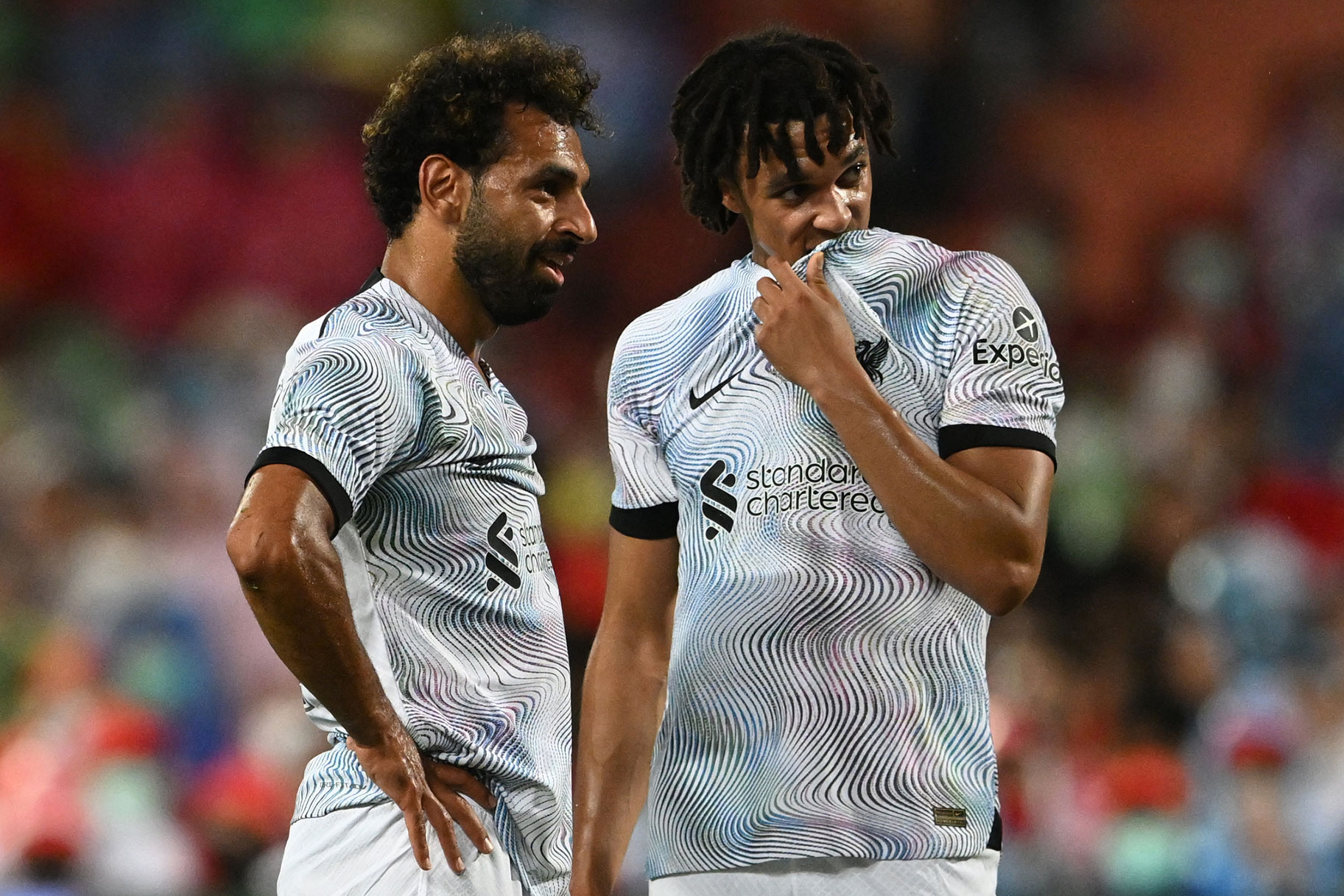 Liverpool's Egyptian forward Mohamed Salah talks with Liverpool's English defender Trent Alexander-Arnold (R) during an exhibition football match
