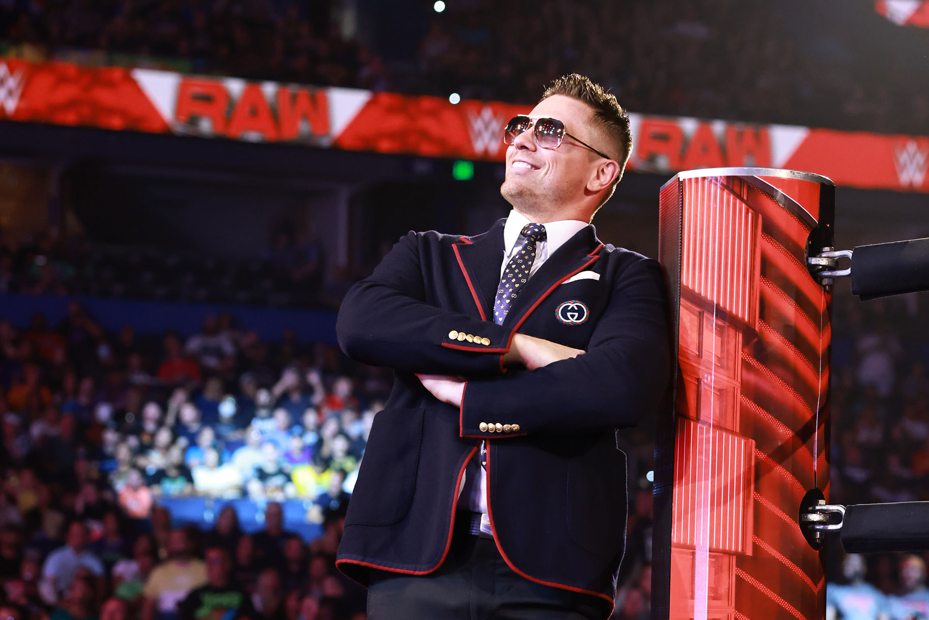 The Miz standing outside of the ring with a smile on his face