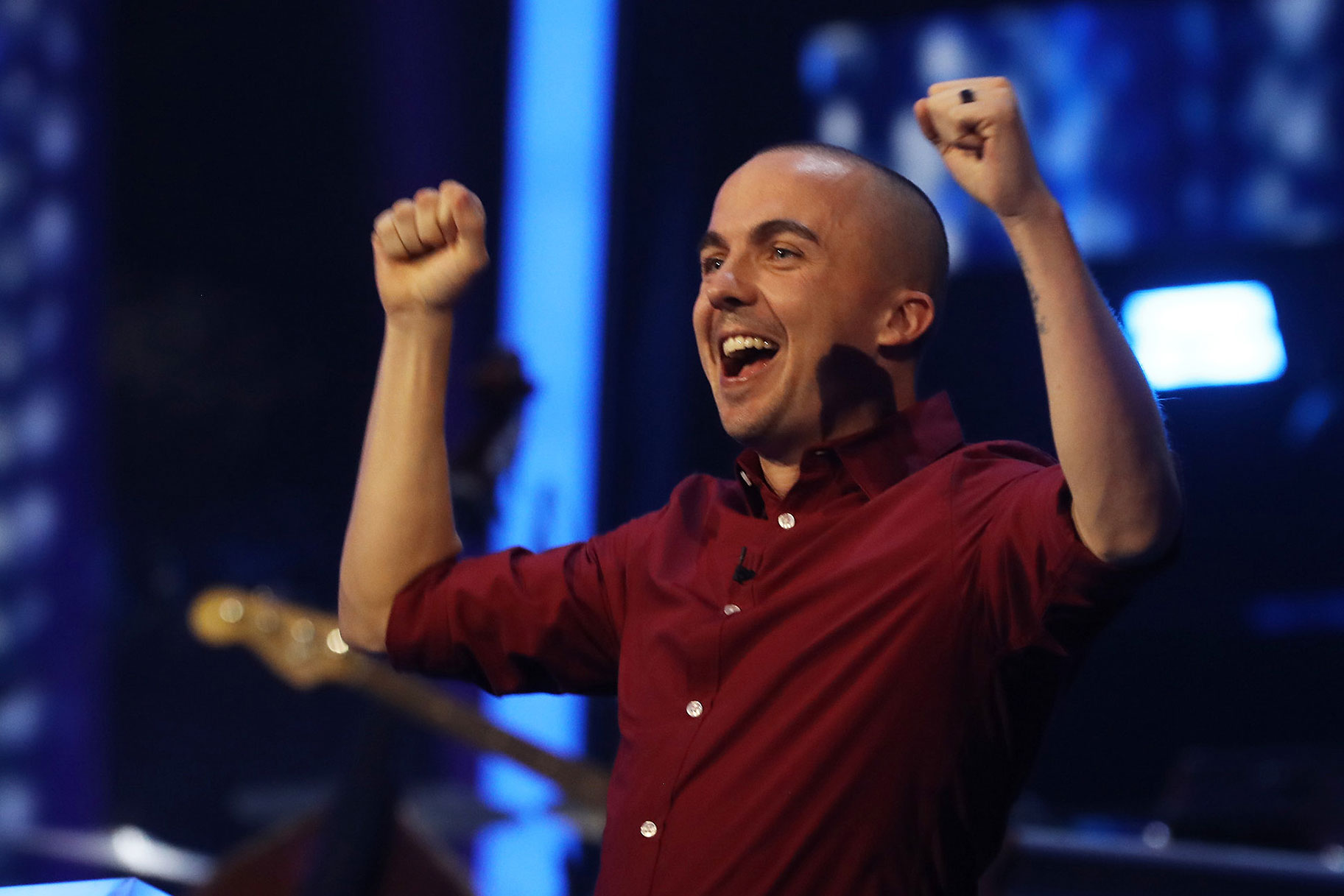 Image of Frankie Muniz with his arms up, cheering