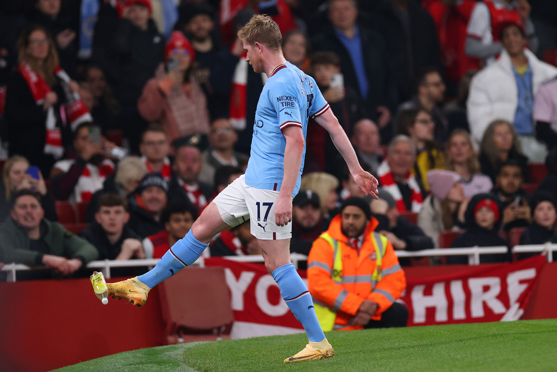 Kevin De Bruyne of Manchester City kicks away a bottle thrown from the crowd during the Premier League match between Arsenal FC and Manchester City at Emirates Stadium on February 15, 2023