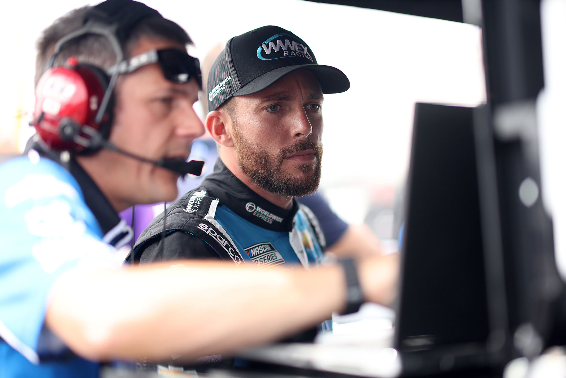 Ross Chastain, driver of the #1 Worldwide Express Chevrolet, and a crew member view a monitor on the grid during practice for the NASCAR Cup Series Ambetter 301 at New Hampshire Motor Speedway on July 16, 2022