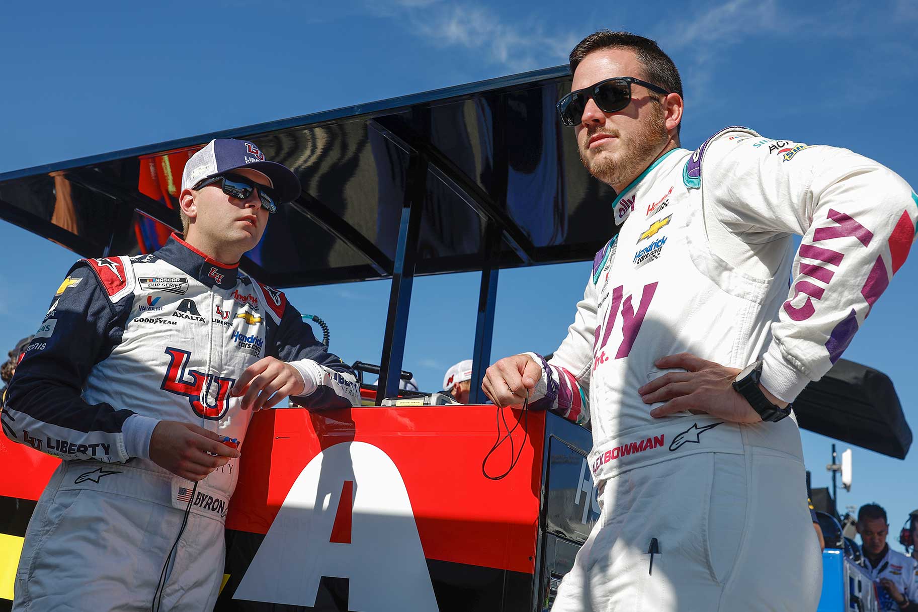 William Byron, driver of the #24 Liberty University Chevrolet, (L) and Alex Bowman, driver of the #48 Ally Chevrolet, talk in the garage area during practice for the NASCAR Cup Series Federated Auto Parts 400