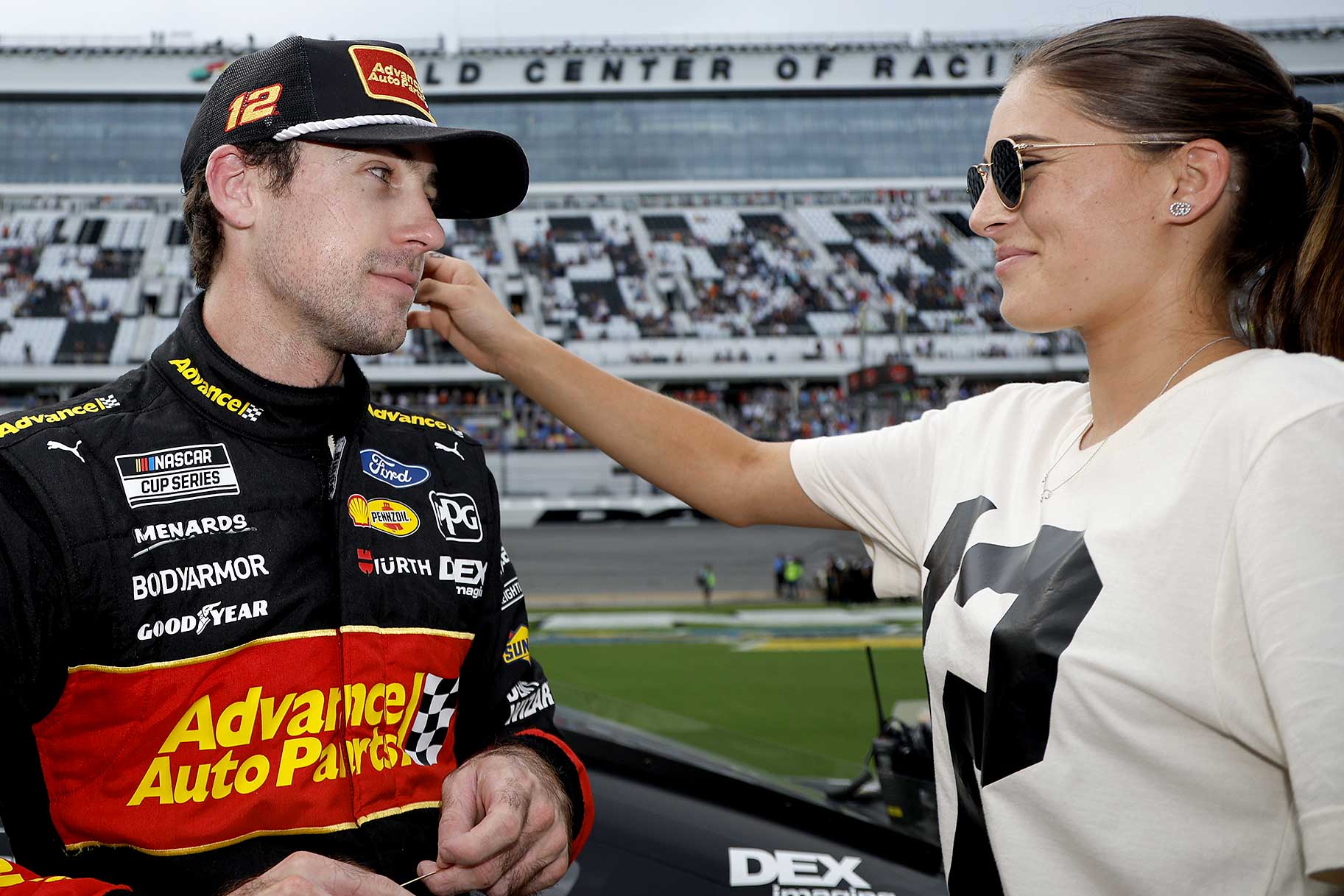 Gianna Tulio touches Ryan Blaney's face next to the track after a race