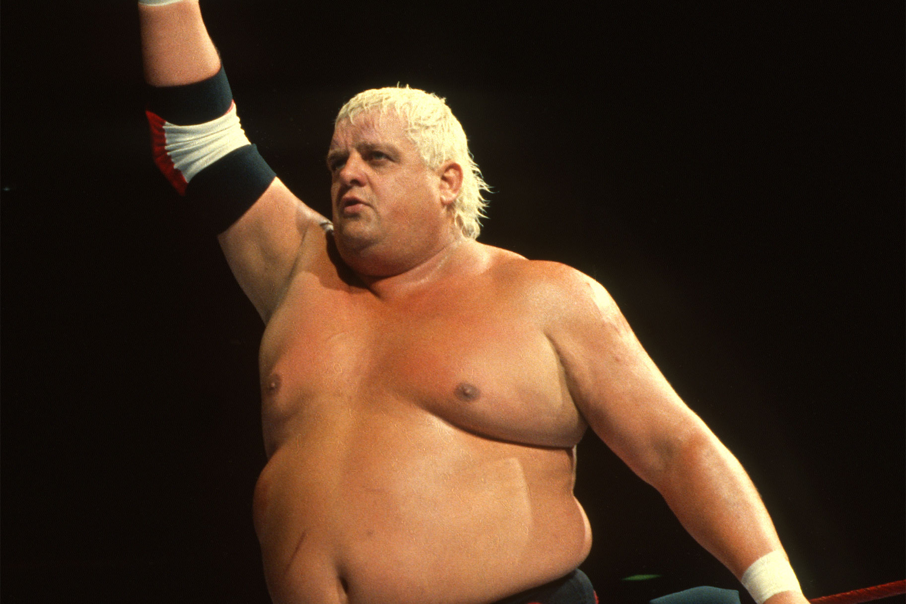 Dusty Rhodes puts his arm in the air during a match