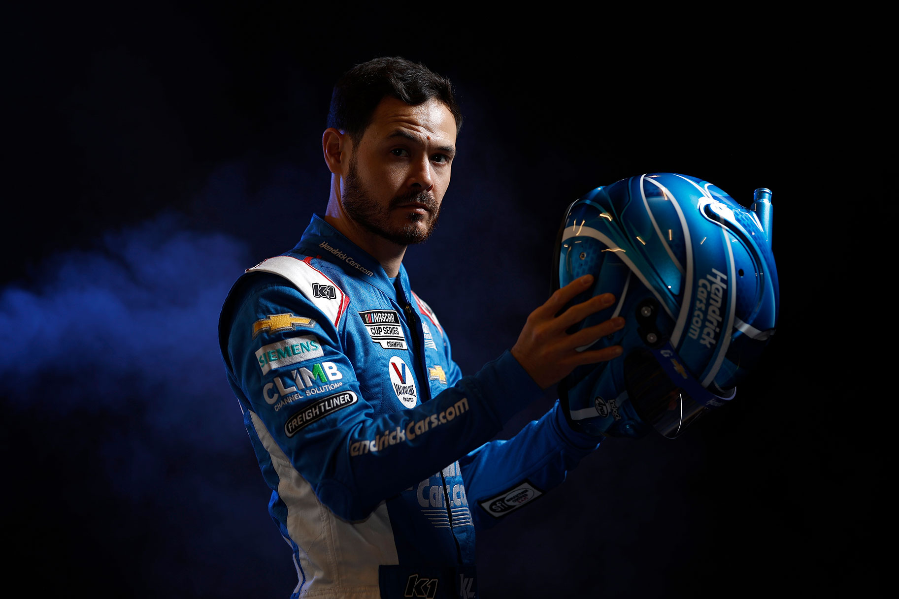 Kyle Larson photographed with his helmet in his hands