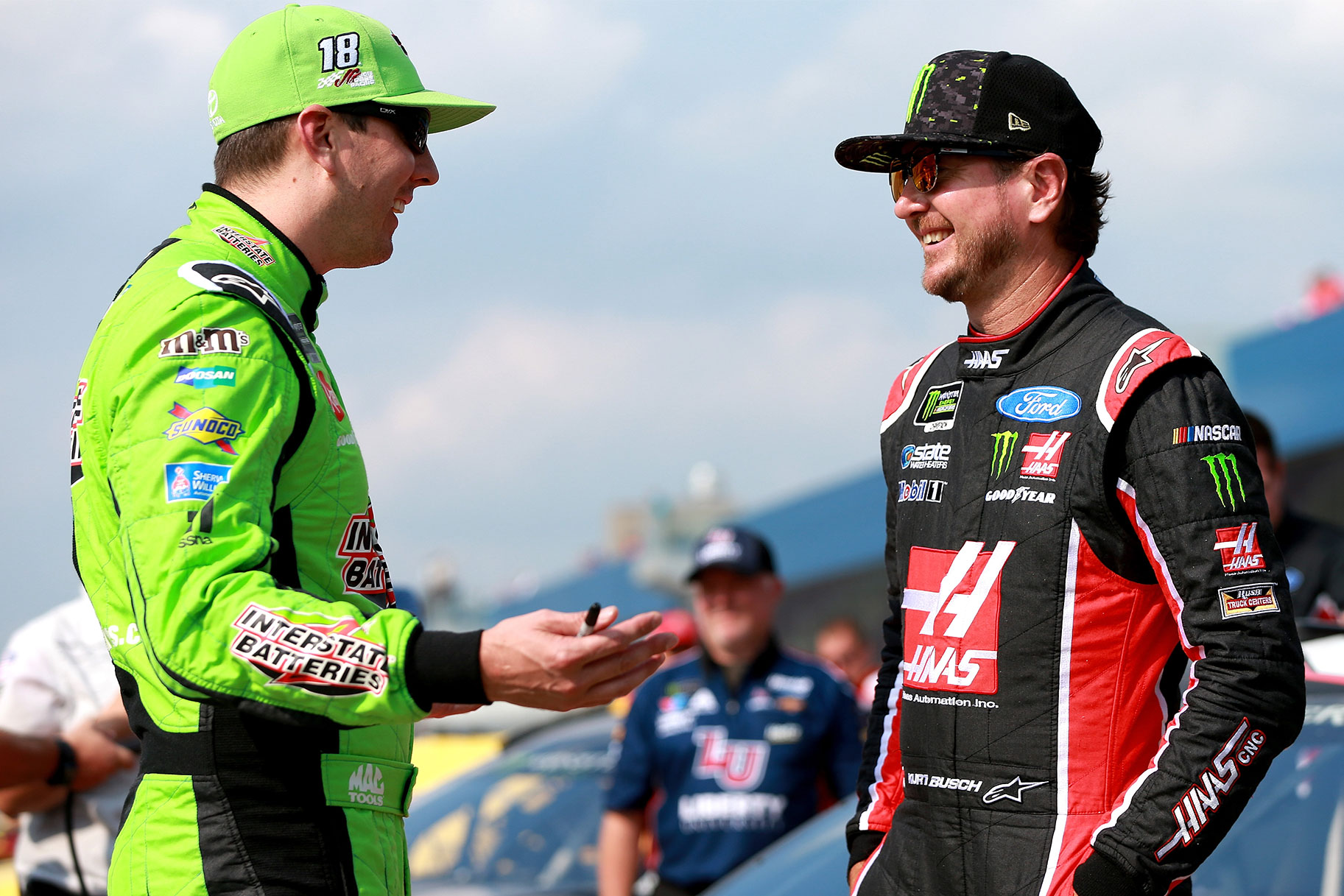 Kyle Busch and Kurt Busch stand together at the Monster Energy NASCAR Cup Series at Michigan International Speedway