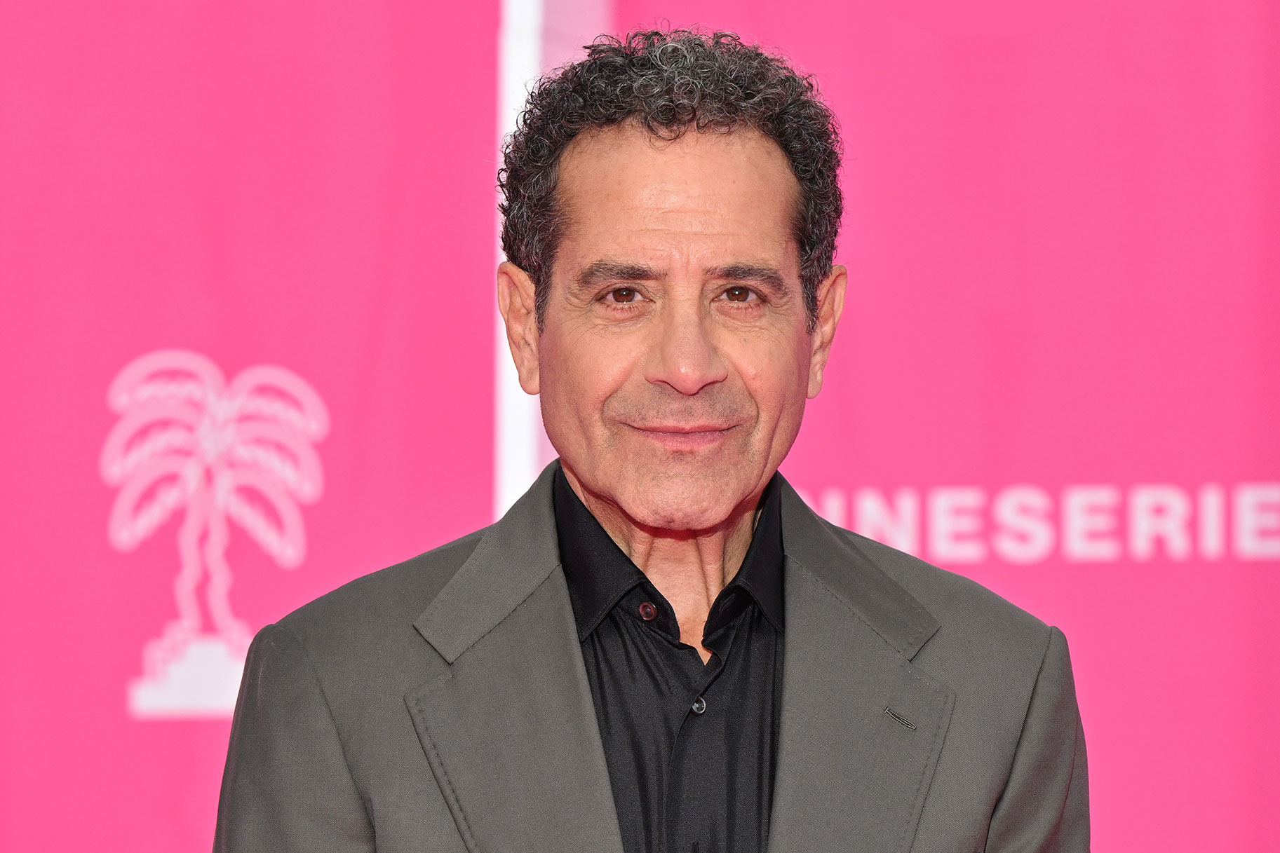 Tony Shalhoub stands in front of a pink backdrop for photo during the 6th Canneseries International Festival