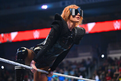 WWE Becky Lynch leaning against the ropes of the ring