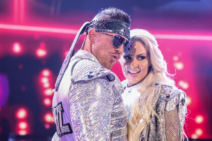 The Miz and Maryse posing together while wearing sparkly silver costumes