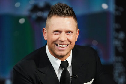 The Miz smiling and wearing a black suit