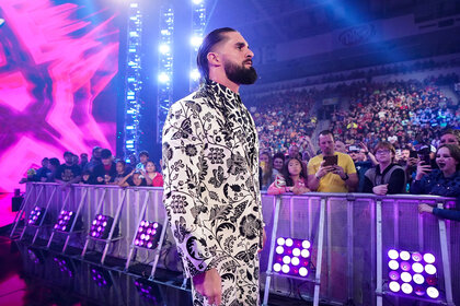 Seth Rollins walking to the ring wearing a black and white, patterned suit