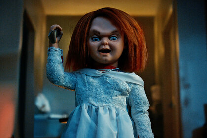 Chucky in a dress, holding a knife