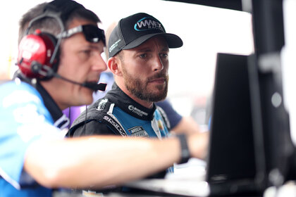 Ross Chastain, driver of the #1 Worldwide Express Chevrolet, and a crew member view a monitor on the grid during practice for the NASCAR Cup Series Ambetter 301 at New Hampshire Motor Speedway on July 16, 2022