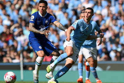 Phil Foden of Manchester City passes the ball whilst under pressure from Enzo Fernandez