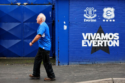 A fan arrives at the stadium prior to a Premier League match