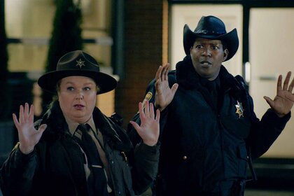 Deputy Liv Baker and Sheriff Mike Thompson hold their hands up on Resident Alien Season 3 Episode 7.
