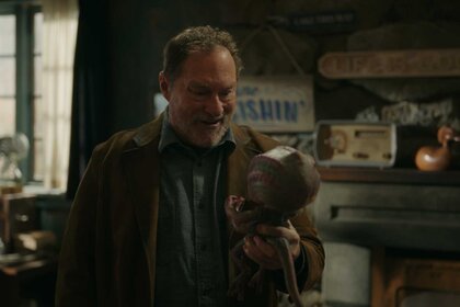 Stephen Root in Resident Alien 407 holding a baby alien