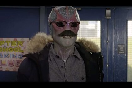 Alien Harry of Resident Alien wearing sunglasses and a fake mustache