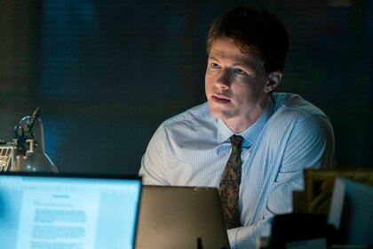 The Rainmaker star Milo Callaghan as Rudy Baylor sitting at computer