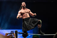 Drew Mcintyre stands on the top of the ropes