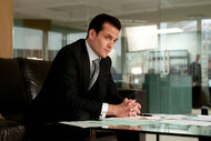 Harvey Spector (Gabriel Macht) sits at a desk in a scene from Suits