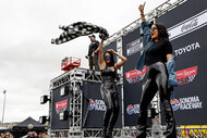 Brie and Nikki Garcia onstage dancing at a NASCAR event