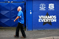 A fan arrives at the stadium prior to a Premier League match