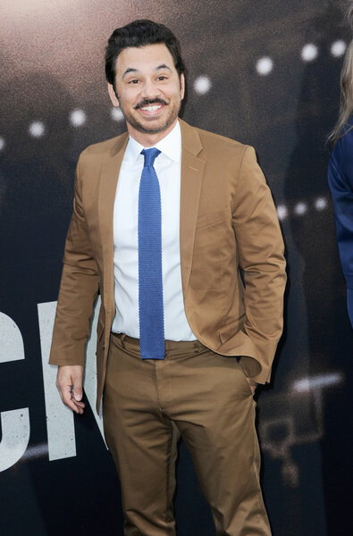Al Madrigal wearing a brown suit and blue tie on the arrivals carpet for The Way Back.