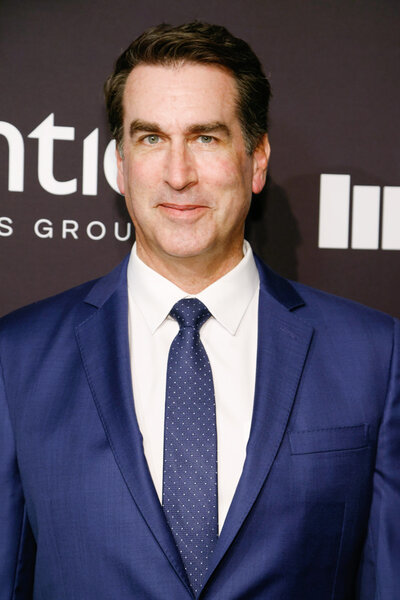 Rob Riggle wearing a blue suit on the Sports Illustrated Sportsperson of the Year arrivals carpet.