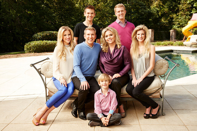 A portrait of the chrisley family sitting poolside