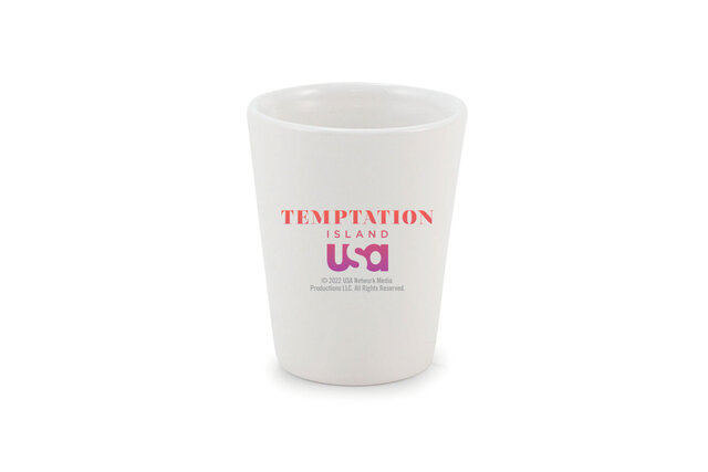 White shot glass that has the tempation island logo on it