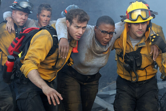 911's Oliver Stark rescuing someone from a fire