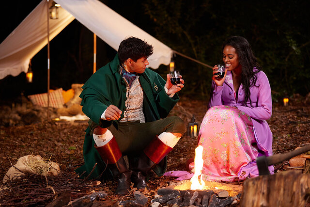 The Courtship's Nicole Remy sitting in front of a camp fire with a suitor