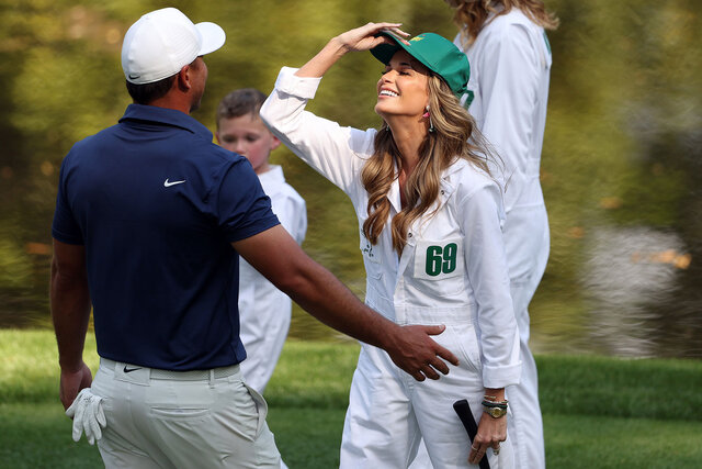 Brooks Koepka and Jena Sims Koepka smile during a golf game