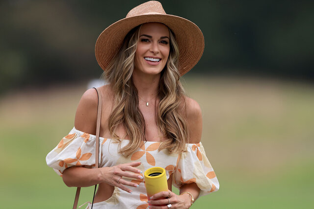 Jena Sims watches Brooks Koepka during a golf match