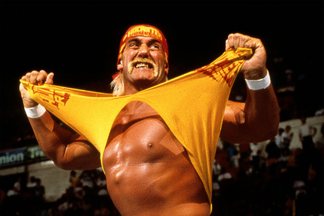 Hulk Hogan tears his shirt while standing in the ring.