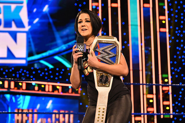 Bayley speaks to the Smackdown crowd as she carries her championship belt on the shoulder