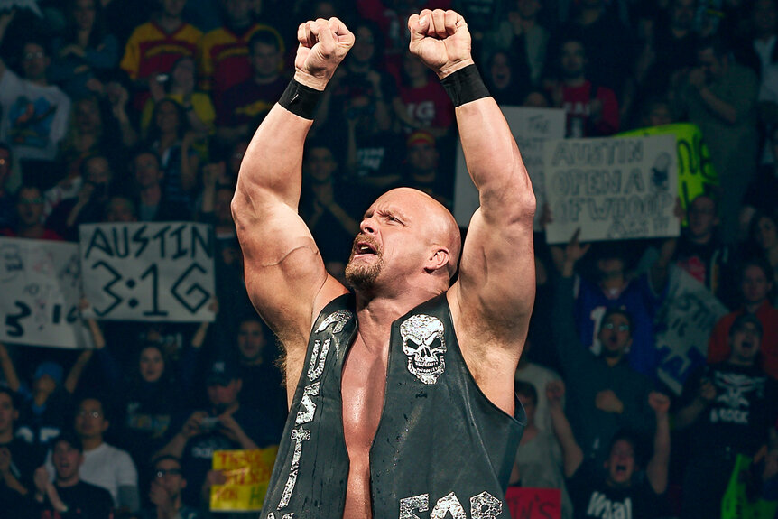 Stone Cold Steve Austin climbing the ropes of the ring with his fists up