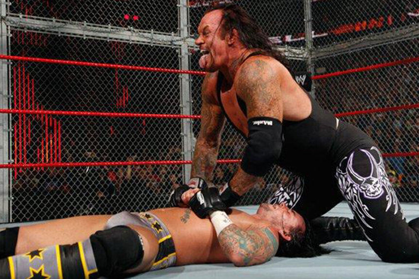 The Undertaker pinning CM Punk during their 2005 Hell In A Cell match