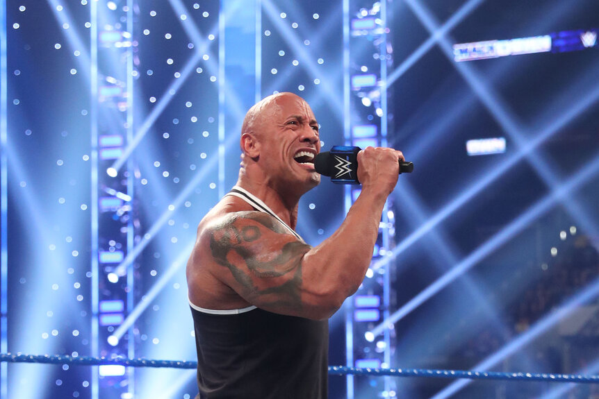 The Rock speaking into a mic during Smackdown
