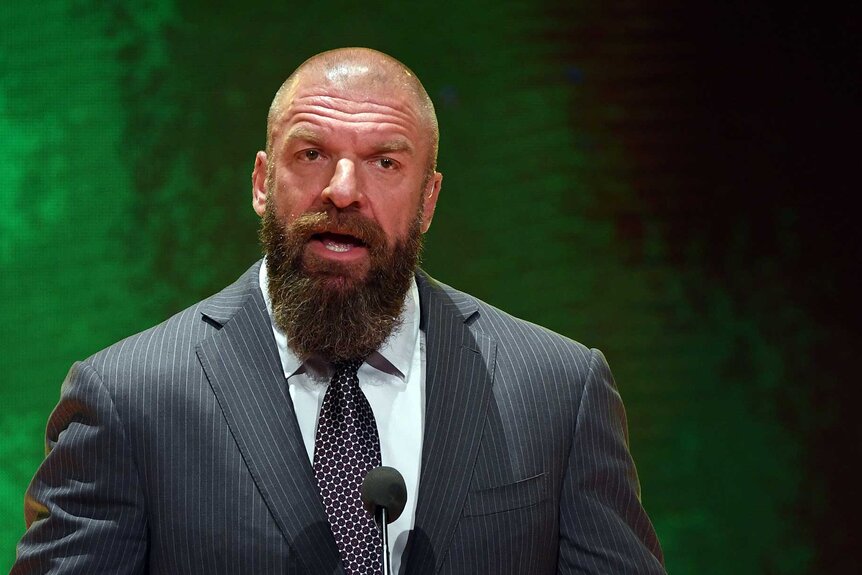 Triple H speaking into a mic
