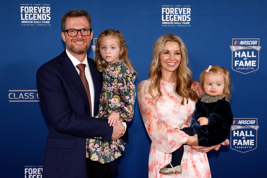 Dale Eanrhardt and his wife and two children pose and smile on the NASCAR Hall of Fame Ceremony red carpet
