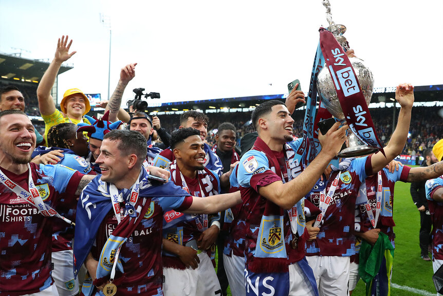 Anass Zaroury of Burnley holds the trophy high after beating Cardiff